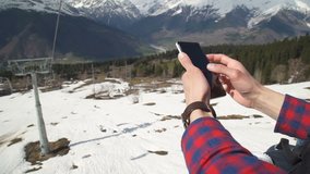 man uses a smartphone to video a beautiful view in the mountains