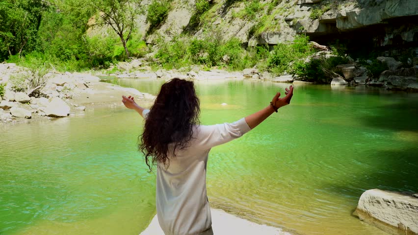 woman hugging in front of green river