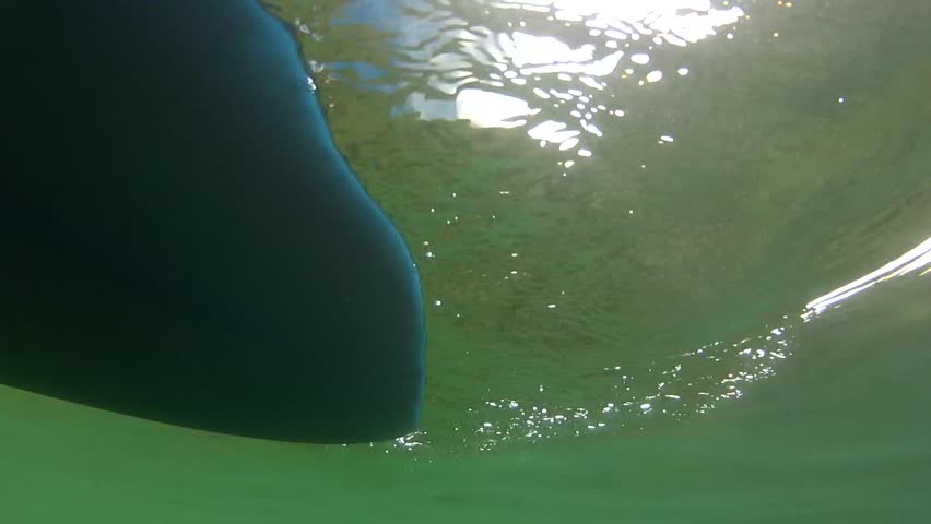 Underwater shot of ocean kayak floating on the surface