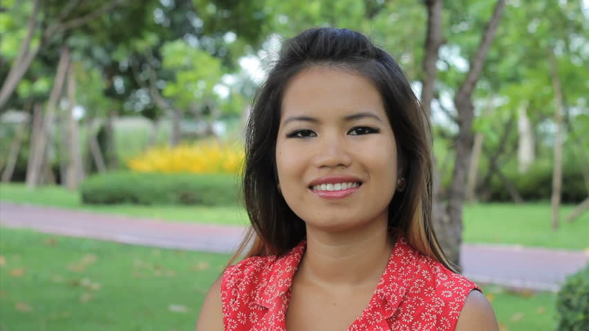 A beautiful Thai girl does a traditional Thai "wai" greeting in t...