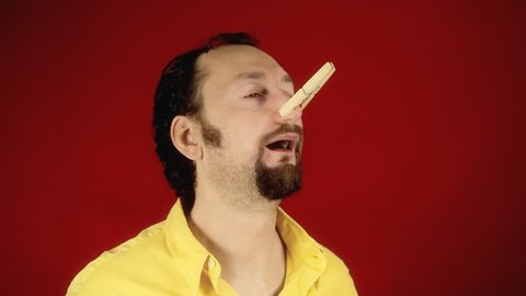A funny guy smelling a bad stink or foul odor and closing his nose with a clothespin, finally finding the peace of mind.
