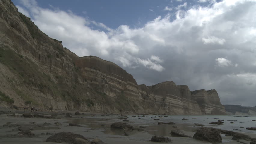 large, eroding cliffs show sedimentary layers from down over the ages.Timelapse