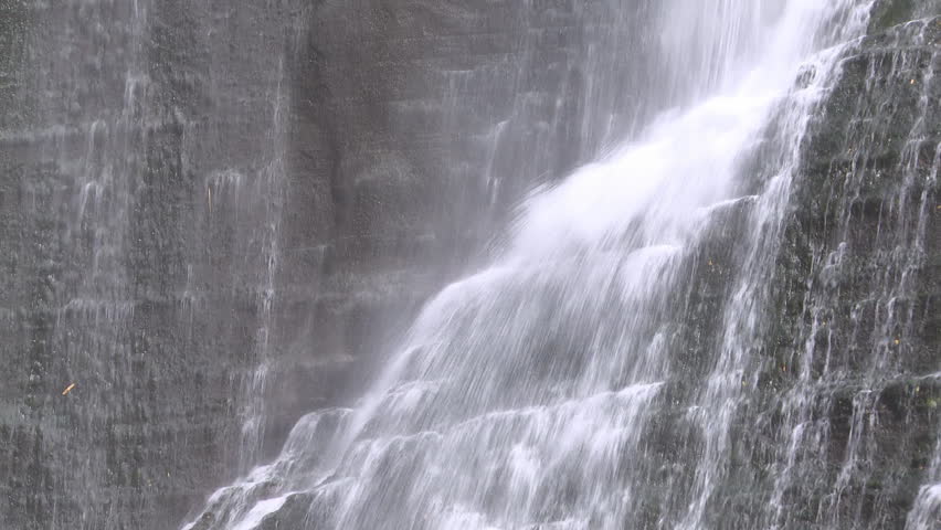 closeup of water cascading down the rock face of a beautiful waterfall