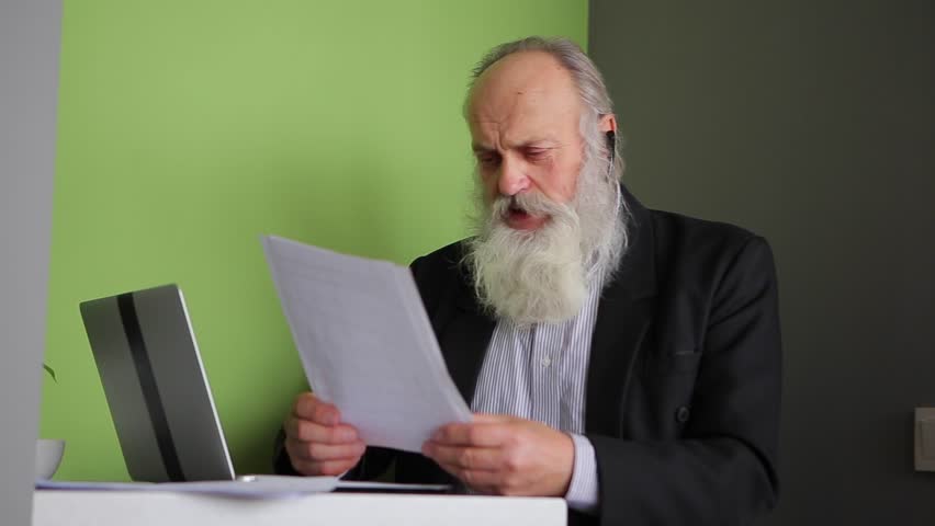 Antediluvian Male Entrepreneur and Politician in Order to Improve Internal Work of Company Speaks on Bluetooth Headset and Enhances International Cooperation, Sits in Office of Enterprise in Daytime.