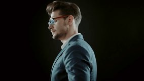 Handsome young manager posing on black background, 4k Red Epic slow motion clip