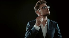 Handsome young manager posing on black background, 4k Red Epic slow motion clip