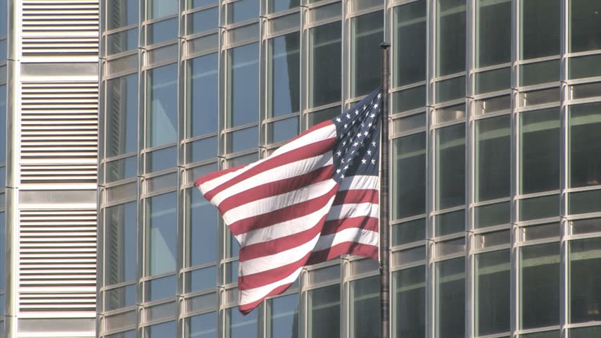 An American flag waving in front of the facade of a building in Chicago 
