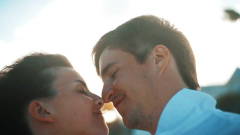 4k ultrahd selfie shot Happy young couple kissing at golden sunset on tropical island in honey moon holiday. Blurred in bokeh beach and sea ocean.