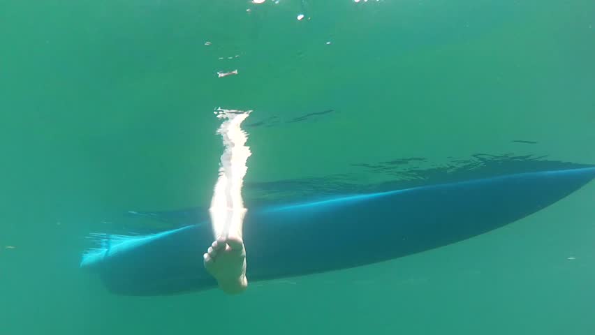 Underwater shot beneath ocean kayak as it floats on the surface of the sea