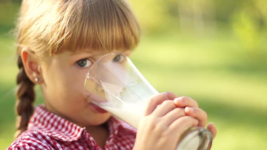 Portrait of smiling girl drinking milk. Milk mustache.
