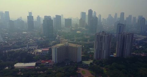 Aerial view of Jakarta city with the new Semanggi interchange and skyscrapers in the misty morning, shot in 4k resolution