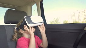 Little Girl a car rides around the city in the helmet of virtual reality. 360 VR Technology.