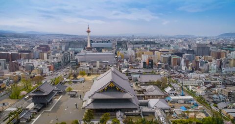 Aerial shot above buddhist temple in Kyoto with city skyline and blue sky, Japan