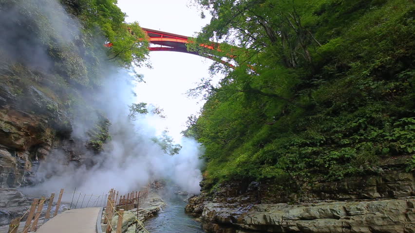 The Kawarayu Bridge standing over the geyser of Oyasukyo Valley. Autumn Colors at Oyasukyo Hot Spring Gorge in Yuzawa city, Akita, Japan.