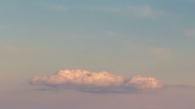 Russia, time lapse. Formation and rapid movement of white clouds of different shapes in the blue sky in late spring at sunset.