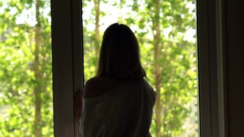Woman unveil curtains and walking out on terrace, super slow motion 240fps
