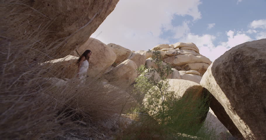 Girl walking in the desert through the rocks and caves. Mojave desert views. Slow motion