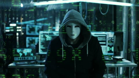 Dangerous Internationally Wanted Hacker with Masked Face Speaks into the Camera with Raining Numbers Video Effect. In the Background His Operating Room with Multiple Displays and Cables.RED Cinema UHD