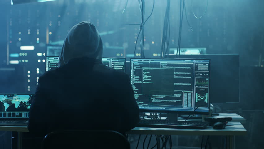 Dangerous Hooded Hacker Breaks into Government Data Servers and Infects Their System with a Virus. His Hideout Place has Dark Atmosphere, Multiple Displays, Cables Everywhere. Shot on RED EPIC Camera. Royalty-Free Stock Footage #27246226