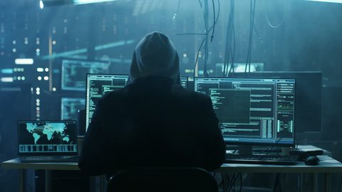 Dangerous Hooded Hacker Breaks into Government Data Servers and Infects Their System with a Virus. His Hideout Place has Dark Atmosphere, Multiple Displays, Cables Everywhere. Shot on RED EPIC Camera.