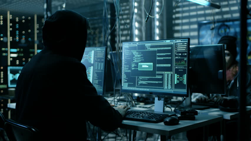 Hooded Hacker and His Group Break into Corporate Data Servers. Place Has Dark Atmosphere, Multiple Displays, Cables Everywhere. Shot on RED EPIC-W 8K Helium Cinema Camera. Royalty-Free Stock Footage #27247468