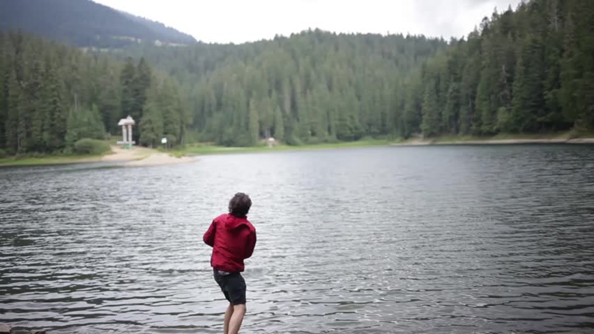 Traveler.The guy in the red windbreaker.The guy in the mountains.A man throws stones at the lake.Beautiful man.
