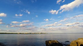 Toronto waterfront skyline from Humber Bay Park with moving white clouds in blue sky. Time lapse video