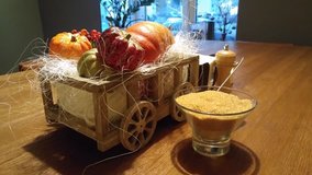 Composition from small artificial pumpkins in wood cart near brown sugar on table in cafe close-up, mobile phone video.