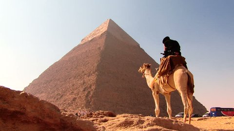 CAIRO, EGYPT - December 2008: Tourists seated at Giza complex on a sunny day with pyramids