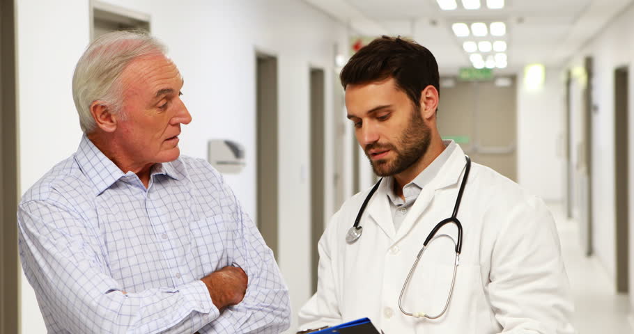 Doctor and patient discussing over clipboard in the corridor at hospital | Shutterstock HD Video #27267643