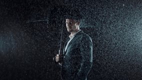 Young man standing in the rain, slow motion 4k Red Epic clip