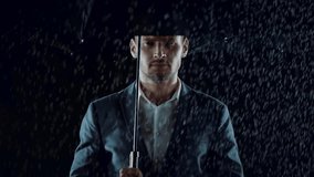 Young man standing in the rain, slow motion 4k Red Epic clip