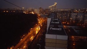 Road near Sokolniki park and illuminated apartment buildings of Moscow in evening, mobile phone video.