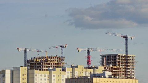 Construction cranes are erecting the walls of new buildings, common view