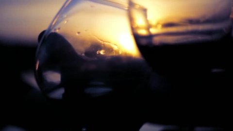 Two wine glasses in the background of a beautiful sunset with delicious drinks. slow motion. 1920x1080. full hd