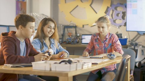 Boy Controls Mini Drone and Two Girls Watch. They're at School in Science Class on a Robotics Lesson. Shot on RED EPIC-W 8K Helium Cinema Camera.