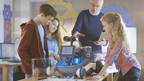 Teacher and His Pupils Work on a Programable Robot with LED Illumination for School Science Class Project. Shot on RED EPIC-W 8K Helium Cinema Camera.