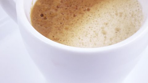 Rotating a white cup with coffee
