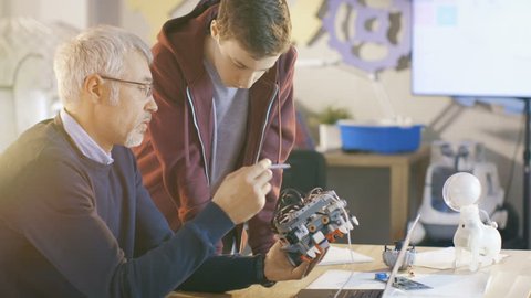 In Computer Science Class Teacher Examines programed Robot Engineered by His Student for School Project. Shot on RED EPIC-W 8K Helium Cinema Camera.