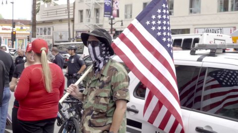LOS ANGELES - MARCH 26, 2017: Militant White Nationalist Waving Flag Pro Trump Event Hollywood Blvd 4K LA California. The wave of white nationalism sweeping the country can be seen at Trump rallies.