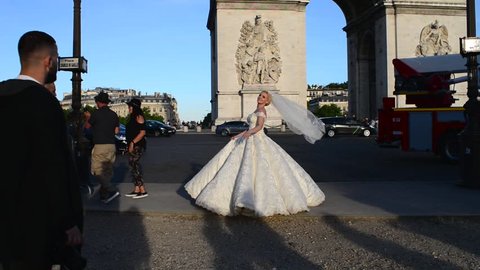 PARIS, FRANCE - MAY 21, 2017: Young Bride in White Dress Photo session near Arc De Triomphe in Paris