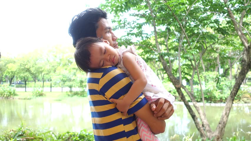 Father was carrying his daughter to sleep.