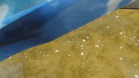 Abstract background of the blue-white cloth fluttering in the wind over clear water -50s. Outdoor video of a Calm, natural background of the water, soundless, Video can be looped