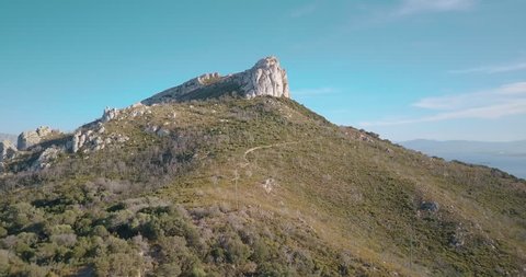 View from above. Aerial video shot by a drone of a trekking to the top of the mountain at sunset. Emerald coast, Sardinia, Italy.