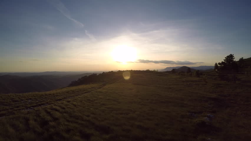 4K Aerial : Mountain biker riding on a sunset trail