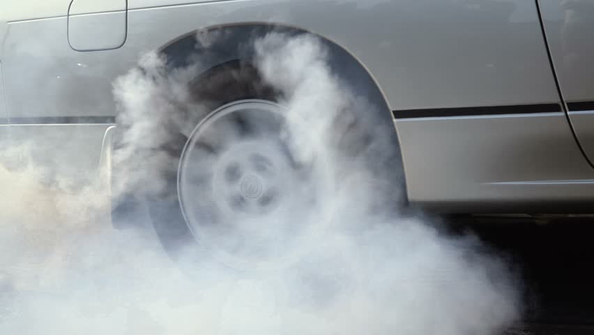 Drag racing car burns rubber off its tires in preparation for the race