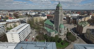 Aerial view drone footage of Helsinki old Lutheran church built in 1912 of grey granite, area, gardens, residential buildings and urban city skyline view in the capital of Finland, northern Europe