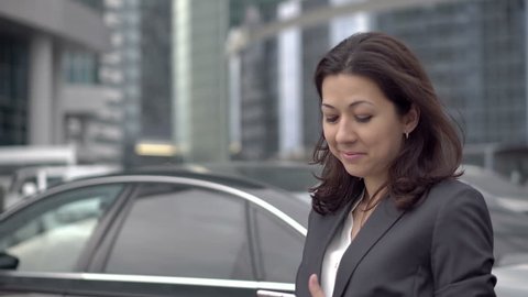 A young successful woman in a suit emerged from the office to the street to call for personal reasons. She leads a pleasant conversation. HD 1920x1080