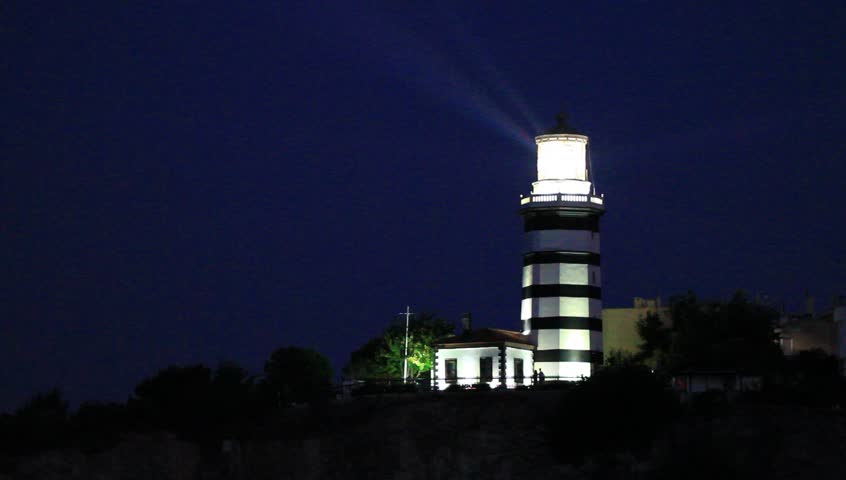 Lighthouse at night with its ever searching light beams

