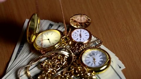 Recalculation of paper bills American dollars and pocket watches in a gold case and chain 